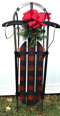 a christmas decoration made out of an old sled with a red bow on top