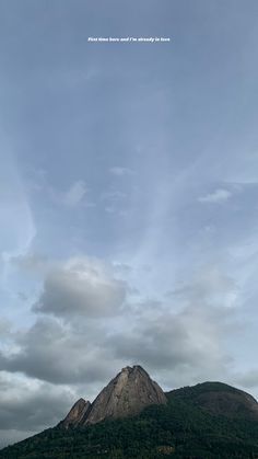 a mountain with clouds in the sky above it