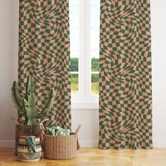 a green and pink patterned curtain next to a potted cactus