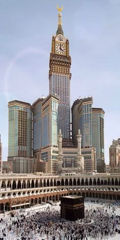 a large group of people standing in front of a tall building with a clock on it