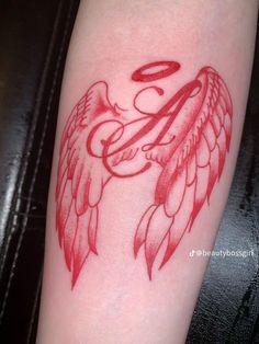 a red tattoo with an angel wing and the letter e on it's arm