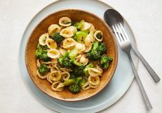 a bowl filled with pasta and broccoli on top of a table