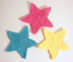 three crocheted stars on a white surface