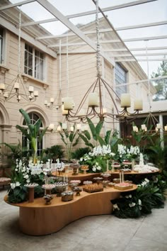 a table that has some food on it in front of a building with lots of greenery