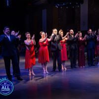 a group of people standing on top of a stage with their hands in the air