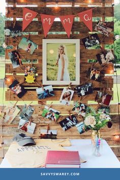 a table topped with pictures and photos on top of wooden pallets covered in string lights