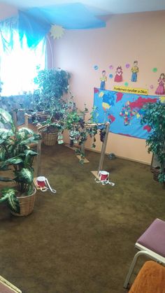 there are many potted plants in the room and one is on the floor with toys