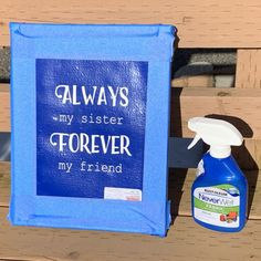 a blue sign sitting on top of a wooden bench next to a bottle of cleaner