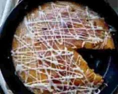 a pan filled with food covered in icing on top of a stove burner