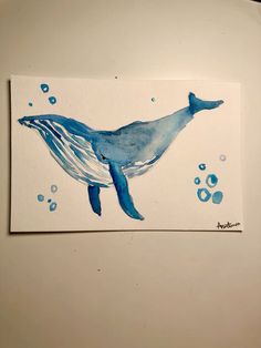 a watercolor drawing of a blue whale with bubbles on it's back end