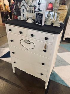 a white dresser sitting on top of a checkered floor