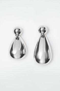 Sculpted in a chunky shape, these striking earrings evoke the image of water droplets cascading from the ear. Intentionally mismatched, they comprise a pair of spherical studs with tonal pendants that can be removed to change up the look. The polished silver coating promises an enduring shine, while the COS-engraved push pack guarantees a secure fit. Push-back closureConvertible designBrass is a versatile material that can be recycled numerous times without losing any of its properties  Shell: 100% Post-consumer recycled brass. Coating: 100% Silver. Excluding trims Earring 1 drop: 1.57". Earring 2 drop: 0.98" Hamered Earrings, Droplet Earrings, Raffia Bag, Leather Flip Flops, Water Droplets, Brown Silver, Midi Dress With Sleeves, Women Accessories Jewelry, Hat Hairstyles