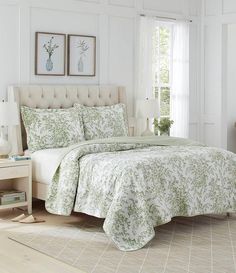 a bedroom with white walls and green bedding