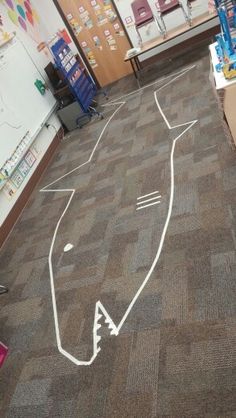 an empty classroom with chalk drawings on the floor