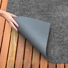 a woman's hand is on the edge of a mat that has been folded over