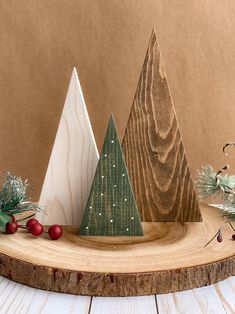 three wooden christmas trees sitting on top of a table