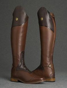 a pair of brown riding boots on grey background