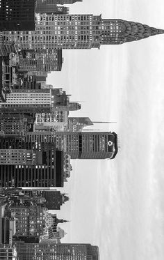 black and white photograph of skyscrapers in new york city with sky line behind them