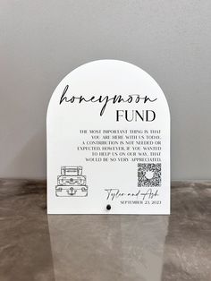 a sign that says honeymoon fund on the side of a table with an image of a suitcase