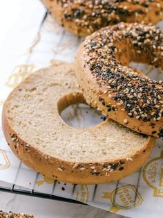 three bagels sitting on top of a table covered in sesame seed sprinkles