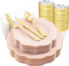 a stack of pink and gold plates with golden spoons on them next to stacks of gold rimmed cups