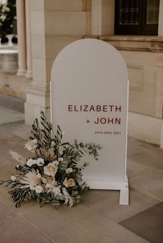 flowers are placed on the ground next to a sign