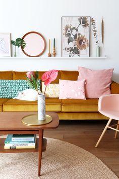 a living room filled with lots of furniture and pictures on the wall above it's coffee table