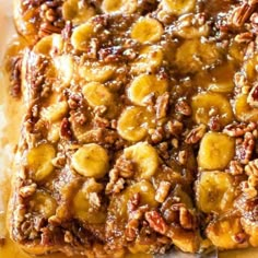 a square piece of bread with bananas and pecans on top