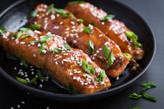 some food is on a black plate with sesame seeds