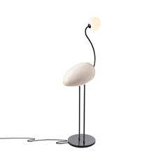 a white flamingo lamp sitting on top of a black stand next to a light bulb