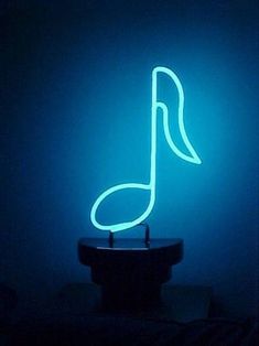 a blue neon sign with a musical note on it's side in the dark