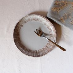 an empty plate with a fork and knife on it, next to a folded napkin