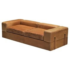 a brown leather couch with two rectangles on the back and one arm extended