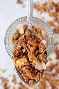 a spoon filled with granola on top of a table