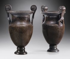 two black vases sitting next to each other