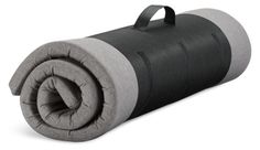 a black and grey sleeping bag is shown on a white background with the top rolled up