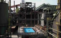 an outdoor swimming pool surrounded by industrial buildings