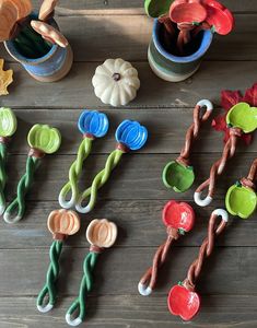 there are many colorful plastic flowers and spoons on the wooden table with other items