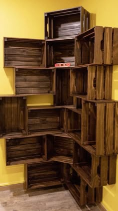 a shelf made out of wooden crates in a room with yellow walls and wood flooring