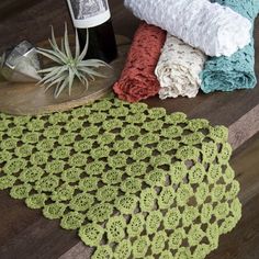 three crocheted doily sitting on top of a wooden table next to a bottle of wine