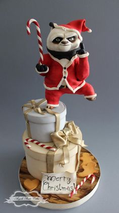 a cake with a santa clause on top and a candy cane in the shape of a panda