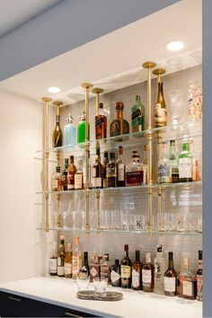 a bar with lots of liquor bottles and glasses on the shelves in front of it