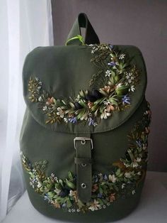 a green bag with flowers and leaves on it