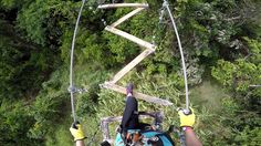 a person on a zip line with trees in the background