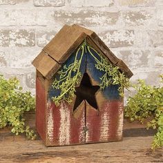 a wooden birdhouse with an american flag painted on it's side and a star hanging from the roof