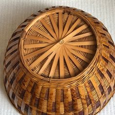 a wicker basket sitting on top of a white cloth covered floor next to a wall