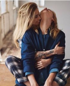 two women sitting on the floor with their arms around each other and one woman's face to her chest