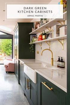 a kitchen with dark green cabinets and white counter tops, gold faucets and brass pulls