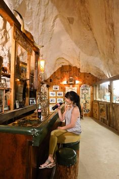 a woman sitting at a bar in a cave