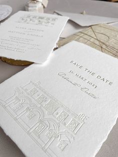 wedding stationery and save the date cards are laid out on top of each other